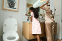 A parent and child next to a bidet.