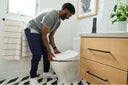 A person installing a Bidetmega 500S on their toilet.