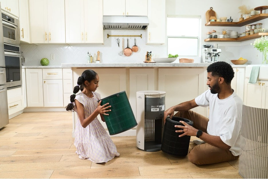 A child and parent opening an Airmega 350.