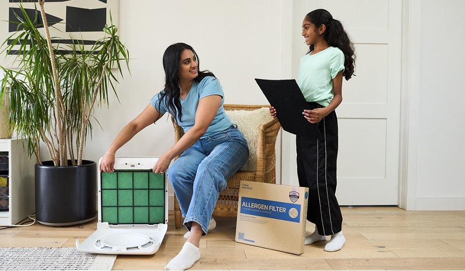 A woman opening an air filter with her daughter.