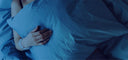 person sleeping holding a pillow