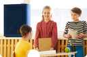 Children in classroom standing by Airmega air purifier